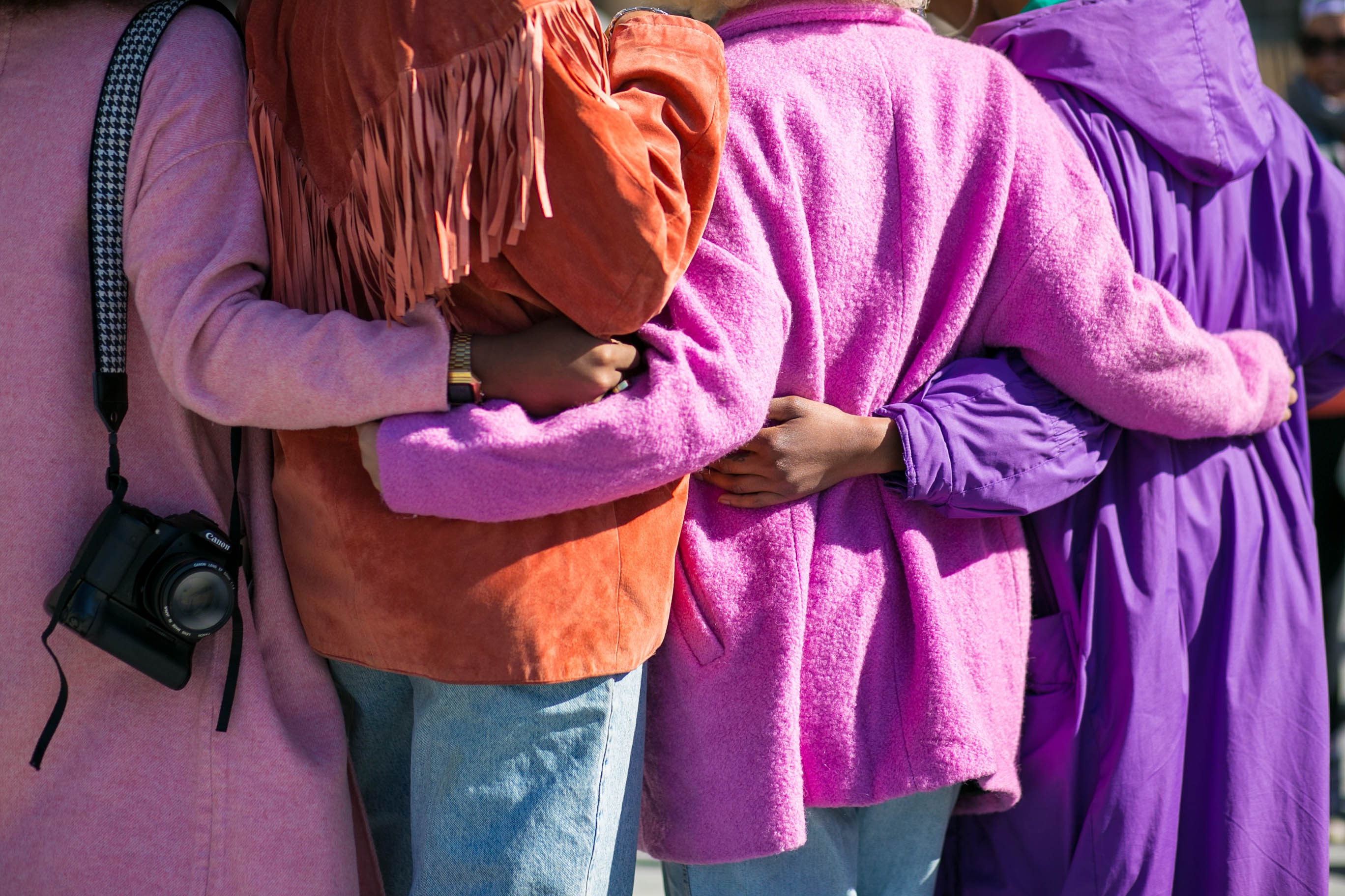 Mujeres abrazandose en paz vistiendo el color violeta
